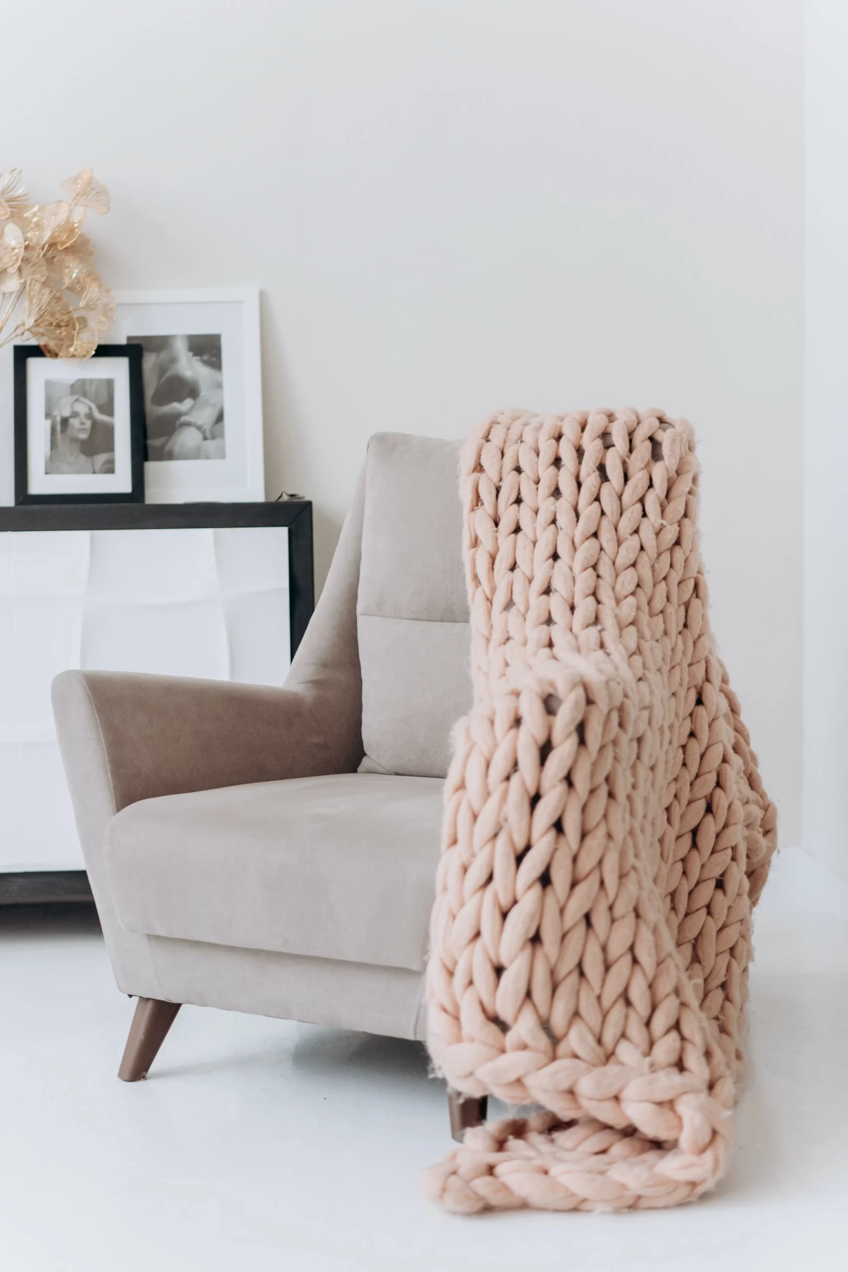rose pink sofa chair with pink crochet blanked draped over side and back of chair